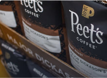Close up image of multiple bags of beans on a grocery store shelf